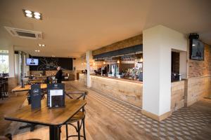 un restaurante con paredes y mesas de madera y un bar en The View, en Welwyn Garden City