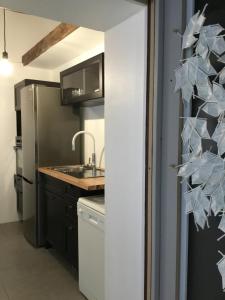 a kitchen with a sink and a refrigerator at Le HWell in Saint-Valéry-sur-Somme