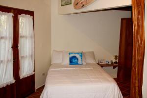Pedasí TownにあるCabañas La Casa de Puchaのベッドルーム1室(青い枕付きのベッド1台付)