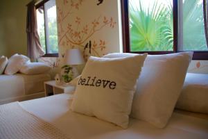 a bed with a pillow with the word relieve written on it at Cabañas La Casa de Pucha in Pedasí Town