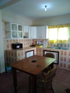 a kitchen with a wooden table and chairs in it at Harmony house apartments in Ker Bakary