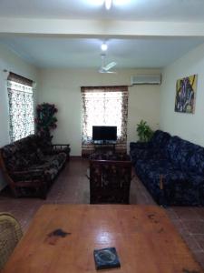 a living room with couches and a table and a tv at Harmony house apartments in Ker Bakary