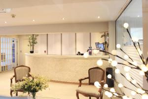 - un hall avec deux chaises et un comptoir de réception dans l'établissement Hotel Las Terrazas Business, à Chillán
