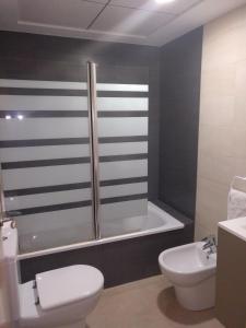 a bathroom with a shower and a toilet and a sink at Sierra Cortina Resort in Finestrat +25 photos