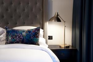 a bedroom with a bed with a pillow and a lamp at Sand Hotel by Keahotels in Reykjavík