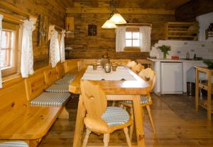 a dining room with a wooden table and chairs at Rüggenhütte in Hochfeistritz