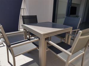 una mesa de madera con 2 sillas y una tapa de cristal en Playa Elisa Bay MP009, en Torre de la Horadada