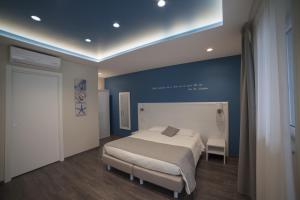 1 dormitorio con cama y pared azul en Residence del sole Manfredonia, en Manfredonia