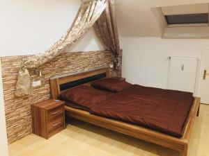 a bedroom with a bed with a brick wall at Ferienwohnung Dhillon in Bernau am Chiemsee