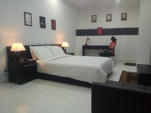 a bedroom with a large bed and a desk and a chair at J. I. T HOTEL in Chaltlāng