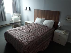 Un pat sau paturi într-o cameră la Hôtel Aux Vieux Bardeaux