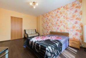 1 dormitorio con cama y pared de flores en "VOLGAHOME", ул Волжская Набережная 21 Берег Волги en Nizhni Nóvgorod