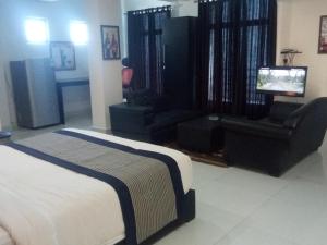 a bedroom with a bed and a chair and a television at J. I. T HOTEL in Chaltlāng