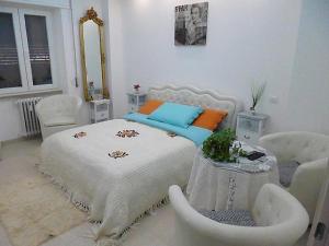 ein Schlafzimmer mit einem weißen Bett und weißen Stühlen in der Unterkunft Siberia Rooms in Verona