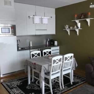 a kitchen with a table and two white chairs at Finnclub Voyage Luxury Appartment in Laukaa