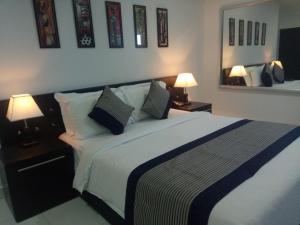 a bedroom with a large bed with two lamps at J. I. T HOTEL in Chaltlāng