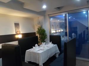 a dining room with a white table and chairs at J. I. T HOTEL in Chaltlāng