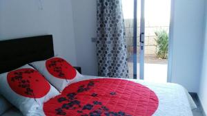 a bedroom with a red and white bed with a window at VILLA Atlantico Views in Candelaria +40 photos