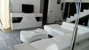 sala de estar con muebles blancos y TV de pantalla plana en LUXURY VILLA Atlantico Views, en Candelaria
