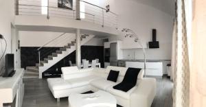 una sala de estar con muebles blancos y una escalera. en LUXURY VILLA Atlantico Views, en Candelaria