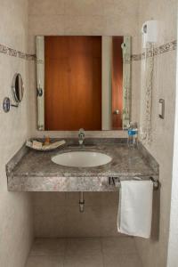 een badkamer met een wastafel en een spiegel bij Las Avenidas in Pachuca de Soto