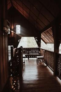 - une terrasse couverte en bois avec un banc dans un bâtiment dans l'établissement Crossroads house, à Mae Hong Son