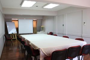 una sala de conferencias con una gran mesa blanca y sillas en Hotel Las Terrazas Express, en Chillán