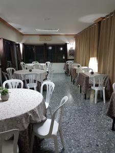 a dining room with tables and white chairs at Pension los Verdiales in La Herradura
