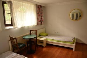 a bedroom with two beds and a table and a mirror at Deeps Hostel Ankara in Ankara
