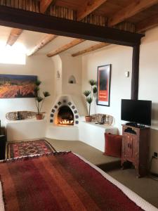a living room with a fireplace and a tv at Old Taos Guesthouse B&B in Taos