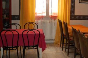 a dining room with a red table and chairs at Hôtel des Jacobines in Chalon-sur-Saône