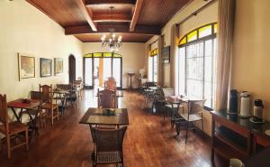 a dining room with tables and chairs and windows at Eden Park Hotel in Sorocaba