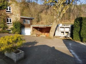 a house with a garage and a tree at Les 3 Canards in Stoumont