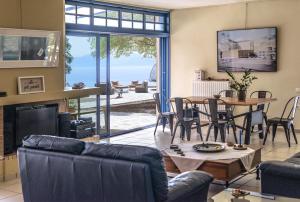 a living room with a fireplace and a table and chairs at Villa Coin de Paradis in Sivota