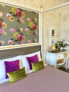 1 dormitorio con 1 cama con almohadas moradas y verdes en B&B Relais Inn Lucca, en Lucca