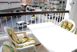 d'un balcon avec des chaises et une table offrant une vue sur la rue. dans l'établissement Corona 204 Apartments Casasol, à Nerja