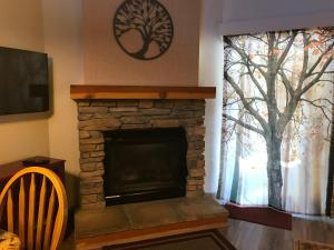 uma sala de estar com uma lareira de pedra e uma janela em Yosemite Condominium em Yosemite West