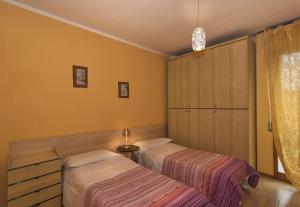2 letti in una camera con pareti gialle di Cisanello Appartamenti Teresa a Pisa