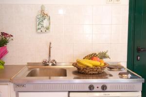 a kitchen counter with a sink and a basket of fruit at Alkmini Studio in Minia