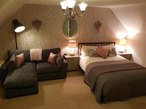 a bedroom with a bed and a couch and a mirror at Westcot in Callander