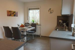 a kitchen with a table and chairs and a sink at Zum Fuchsbau in Hettstadt