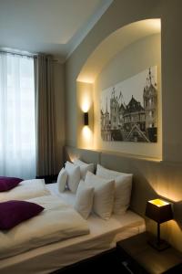 Habitación de hotel con cama grande con almohadas blancas en Hotel Residenz am Königsplatz, en Speyer