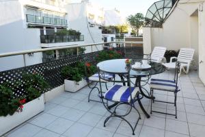 patio con mesa y sillas en el balcón en Mayla Apartments en Buenos Aires