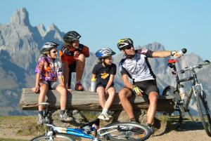 a group of people sitting on a log with their bikes at Alpen Chalet Eben in Eben im Pongau