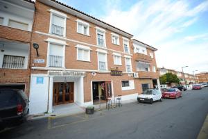 ein Gebäude auf einer Straße mit davor geparkt in der Unterkunft Hotel Montearoma in Valverde del Camino