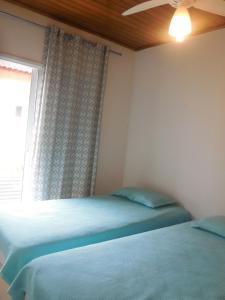 Un dormitorio con dos camas y una ventana en Casa Guarujá - Condomínio, en Guarujá 19 fotos más