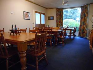 a dining room with wooden tables and chairs at Acacia Rose Motor Inn in Barham