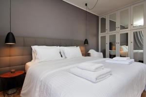 una camera da letto con un grande letto bianco con asciugamani di Central Apartment ad Atene