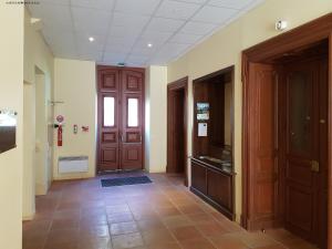 a hallway with wooden doors and a tile floor at Résidence Grand Hôtel in Aulus-les-Bains