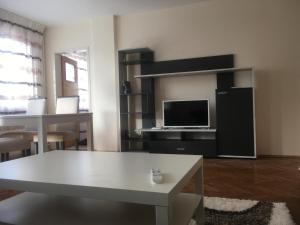 a living room with a white table and a tv at Stylish spacious flat in Sofia